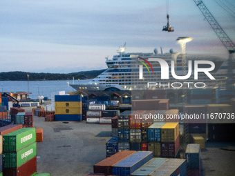 Shipping containers are stacked at the port in Kristiansand, Norway, with the AIDA Cruises ship docked in the background on September 12, 20...