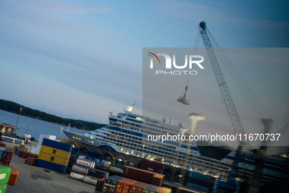 Shipping containers are stacked at the port in Kristiansand, Norway, with the AIDA Cruises ship docked in the background on September 12, 20...