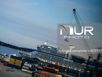 Shipping containers are stacked at the port in Kristiansand, Norway, with the AIDA Cruises ship docked in the background on September 12, 20...