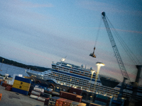 Shipping containers are stacked at the port in Kristiansand, Norway, with the AIDA Cruises ship docked in the background on September 12, 20...