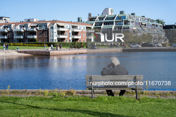 An elderly person sits on a bench overlooking the sea in Kristiansand, Norway on September 13, 2024. Kristiansand is a city and municipality...