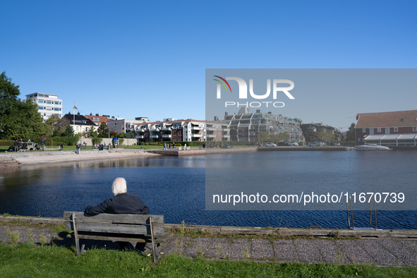 An elderly person sits on a bench overlooking the sea in Kristiansand, Norway on September 13, 2024. Kristiansand is a city and municipality...