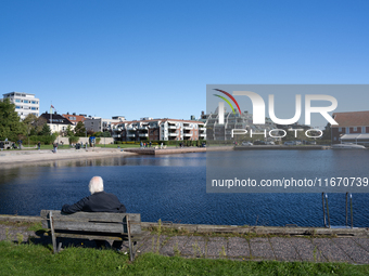 An elderly person sits on a bench overlooking the sea in Kristiansand, Norway on September 13, 2024. Kristiansand is a city and municipality...