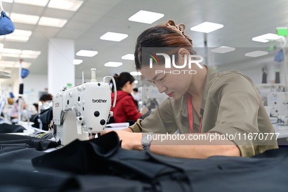 Workers rush to fulfill export orders at the clothing production line of Shaanxi Yanzhong Garment Co., Ltd. in Weinan, China, on October 15,...