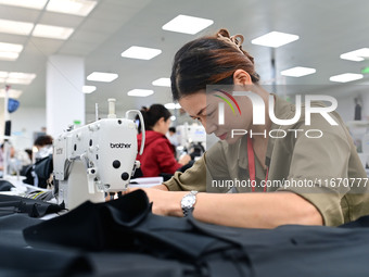 Workers rush to fulfill export orders at the clothing production line of Shaanxi Yanzhong Garment Co., Ltd. in Weinan, China, on October 15,...