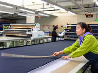 Workers rush to fulfill export orders at the clothing production line of Shaanxi Yanzhong Garment Co., Ltd. in Weinan, China, on October 15,...