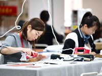 Workers rush to fulfill export orders at the clothing production line of Shaanxi Yanzhong Garment Co., Ltd. in Weinan, China, on October 15,...