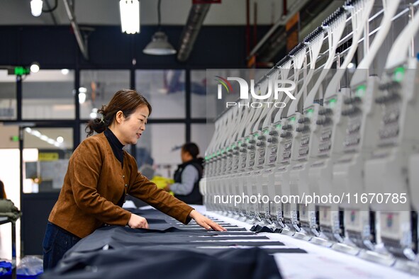 Workers rush to fulfill export orders at the clothing production line of Shaanxi Yanzhong Garment Co., Ltd. in Weinan, China, on October 15,...