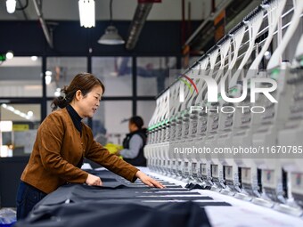 Workers rush to fulfill export orders at the clothing production line of Shaanxi Yanzhong Garment Co., Ltd. in Weinan, China, on October 15,...