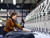 Workers rush to fulfill export orders at the clothing production line of Shaanxi Yanzhong Garment Co., Ltd. in Weinan, China, on October 15,...