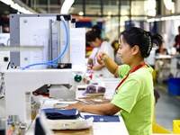 Workers rush to fulfill export orders at the clothing production line of Shaanxi Yanzhong Garment Co., Ltd. in Weinan, China, on October 15,...