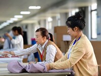 Workers rush to fulfill export orders at the clothing production line of Shaanxi Yanzhong Garment Co., Ltd. in Weinan, China, on October 15,...