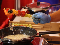 A man coats fruit skewers in molten sugar while preparing Tanghulu (candied fruit skewers) in Markham, Ontario, Canada, on October 5, 2024....