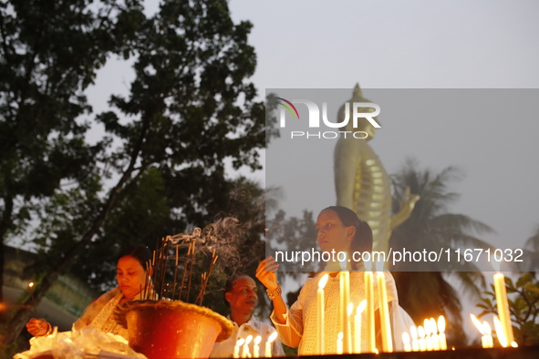 Devotees light candles during the celebrations to mark the Buddhist festival of Probarona Purnima in Dhaka, Bangladesh, on October 16, 2024....