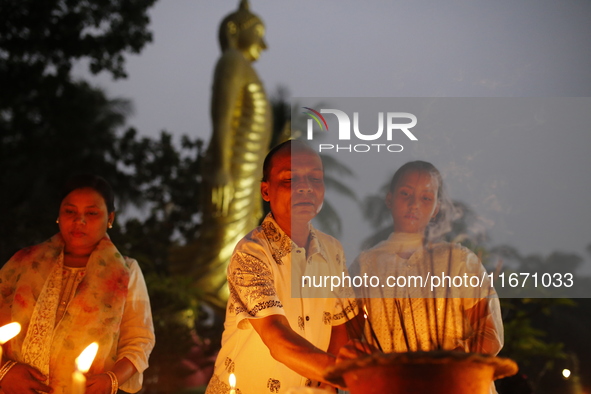 Devotees light candles during the celebrations to mark the Buddhist festival of Probarona Purnima in Dhaka, Bangladesh, on October 16, 2024....