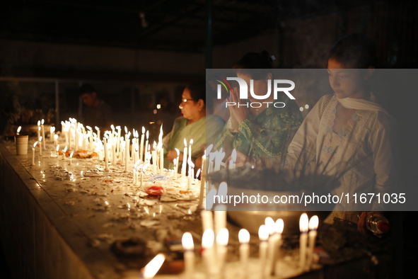 Devotees light candles during the celebrations to mark the Buddhist festival of Probarona Purnima in Dhaka, Bangladesh, on October 16, 2024....