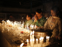 Devotees light candles during the celebrations to mark the Buddhist festival of Probarona Purnima in Dhaka, Bangladesh, on October 16, 2024....