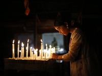 A devotee lights a candle during the celebrations to mark the Buddhist festival of Probarona Purnima in Dhaka, Bangladesh, on October 16, 20...