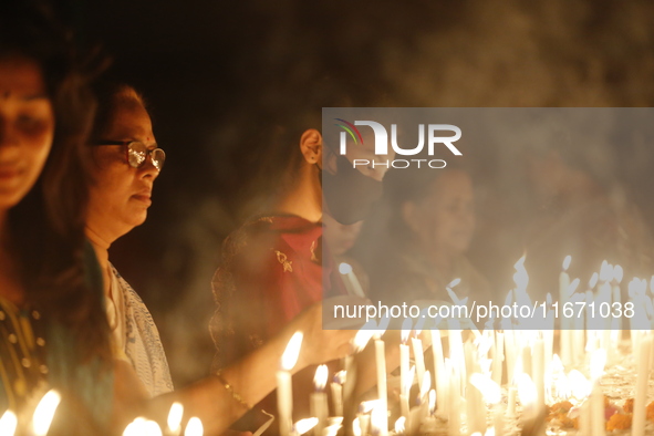 Devotees light candles during the celebrations to mark the Buddhist festival of Probarona Purnima in Dhaka, Bangladesh, on October 16, 2024....