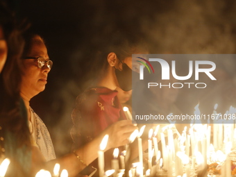 Devotees light candles during the celebrations to mark the Buddhist festival of Probarona Purnima in Dhaka, Bangladesh, on October 16, 2024....