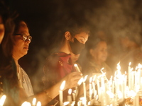 Devotees light candles during the celebrations to mark the Buddhist festival of Probarona Purnima in Dhaka, Bangladesh, on October 16, 2024....