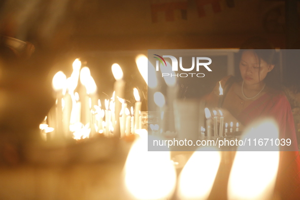 Devotees light candles during the celebrations to mark the Buddhist festival of Probarona Purnima in Dhaka, Bangladesh, on October 16, 2024....