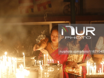 Devotees light candles during the celebrations to mark the Buddhist festival of Probarona Purnima in Dhaka, Bangladesh, on October 16, 2024....