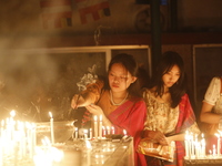 Devotees light candles during the celebrations to mark the Buddhist festival of Probarona Purnima in Dhaka, Bangladesh, on October 16, 2024....