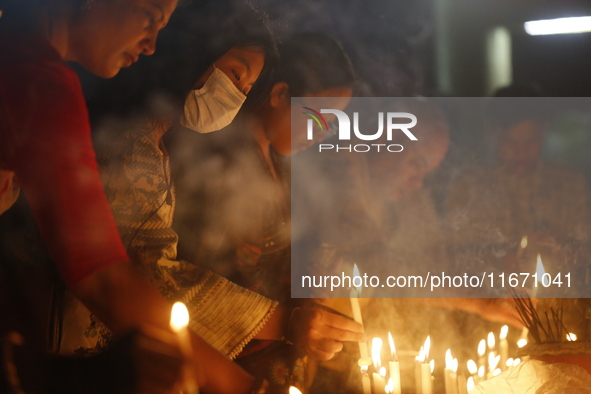 Devotees light candles during the celebrations to mark the Buddhist festival of Probarona Purnima in Dhaka, Bangladesh, on October 16, 2024....