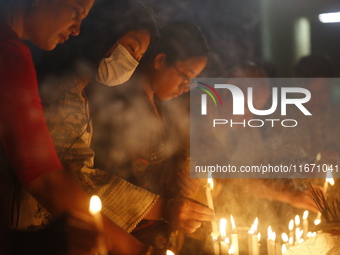 Devotees light candles during the celebrations to mark the Buddhist festival of Probarona Purnima in Dhaka, Bangladesh, on October 16, 2024....