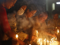 Devotees light candles during the celebrations to mark the Buddhist festival of Probarona Purnima in Dhaka, Bangladesh, on October 16, 2024....