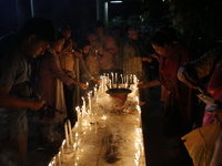 Devotees light candles during the celebrations to mark the Buddhist festival of Probarona Purnima in Dhaka, Bangladesh, on October 16, 2024....