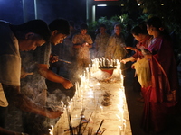 Devotees light candles during the celebrations to mark the Buddhist festival of Probarona Purnima in Dhaka, Bangladesh, on October 16, 2024....