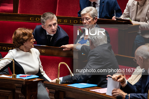 Gil Averous, Minister of Sports and Youth, talks with Prime Minister Michel Barnier among the government benches during question time in Par...