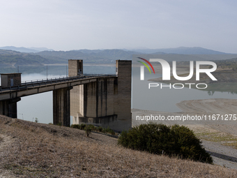 Visible banks, dry soil, and uncultivated vegetation replace the water at Lake Monte Cotugno, a reservoir in Basilicata, which in the summer...