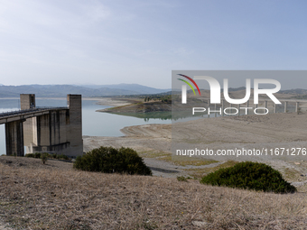 Visible banks, dry soil, and uncultivated vegetation replace the water at Lake Monte Cotugno, a reservoir in Basilicata, which in the summer...