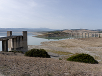 Visible banks, dry soil, and uncultivated vegetation replace the water at Lake Monte Cotugno, a reservoir in Basilicata, which in the summer...