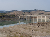 Visible banks, dry soil, and uncultivated vegetation replace the water at Lake Monte Cotugno, a reservoir in Basilicata, which in the summer...