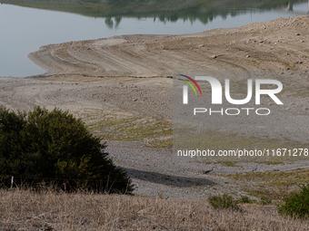 Visible banks, dry soil, and uncultivated vegetation replace the water at Lake Monte Cotugno, a reservoir in Basilicata, which in the summer...