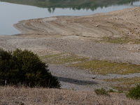 Visible banks, dry soil, and uncultivated vegetation replace the water at Lake Monte Cotugno, a reservoir in Basilicata, which in the summer...