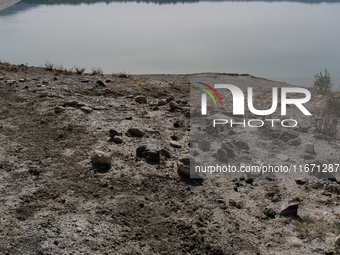 Visible banks, dry soil, and uncultivated vegetation replace the water at Lake Monte Cotugno, a reservoir in Basilicata, which in the summer...