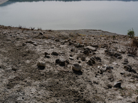 Visible banks, dry soil, and uncultivated vegetation replace the water at Lake Monte Cotugno, a reservoir in Basilicata, which in the summer...