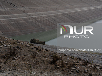 Visible banks, dry soil, and uncultivated vegetation replace the water at Lake Monte Cotugno, a reservoir in Basilicata, which in the summer...