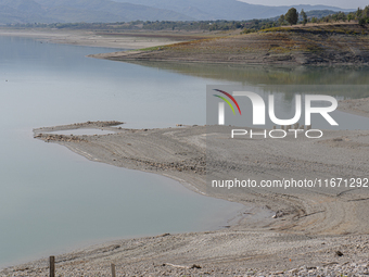 Visible banks, dry soil, and uncultivated vegetation replace the water at Lake Monte Cotugno, a reservoir in Basilicata, which in the summer...