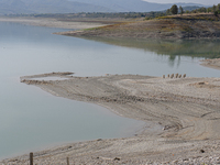 Visible banks, dry soil, and uncultivated vegetation replace the water at Lake Monte Cotugno, a reservoir in Basilicata, which in the summer...