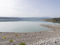 Visible banks, dry soil, and uncultivated vegetation replace the water at Lake Monte Cotugno, a reservoir in Basilicata, which in the summer...