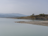 Visible banks, dry soil, and uncultivated vegetation replace the water at Lake Monte Cotugno, a reservoir in Basilicata, which in the summer...