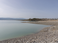 Visible banks, dry soil, and uncultivated vegetation replace the water at Lake Monte Cotugno, a reservoir in Basilicata, which in the summer...