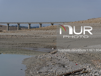 Visible banks, dry soil, and uncultivated vegetation replace the water at Lake Monte Cotugno, a reservoir in Basilicata, which in the summer...