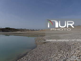 Visible banks, dry soil, and uncultivated vegetation replace the water at Lake Monte Cotugno, a reservoir in Basilicata, which in the summer...